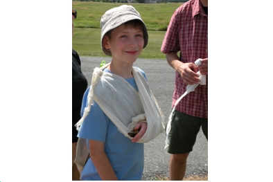 A happy camper demonstrates a rustic sling in Nature First-Aid