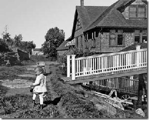 Doris Wyckoff, the youngest of son Clarence's four daughters. Clarence "got stuck" with the inherited Villa. His older brother, Edward, enjoyed a more manageable summer home on the point. The Wyckoff skiff house appears beyond the ramp to a smaller boat house. One of the retaining walls of the Villa garden appears in the left distance. 